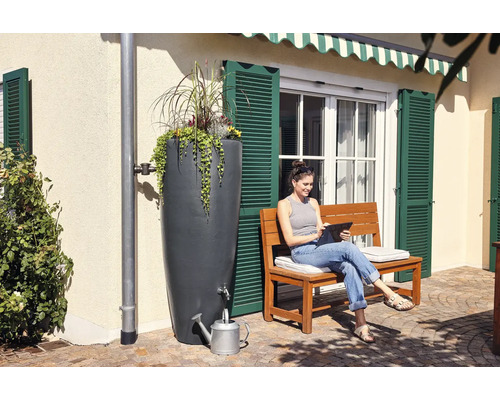 Récupérateur d''eau de pluie avec plantation et femme avec tablette sur un banc