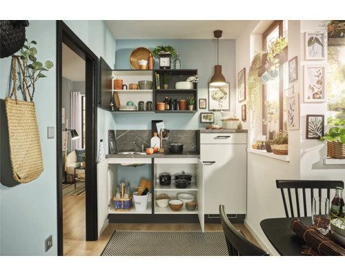 Kompakte Küche mit Spüle, Stauraum und Hängeschränken in einem hellen Raum.