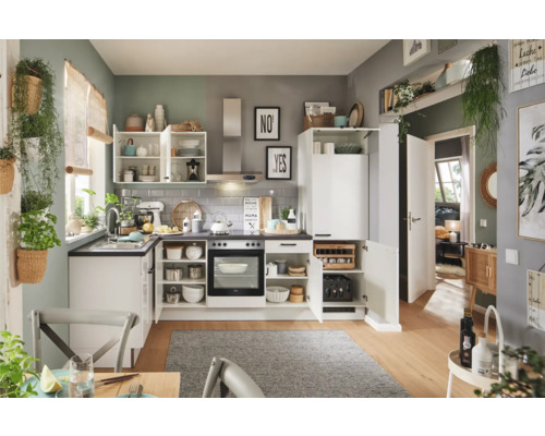 Cuisine lumineuse avec des armoires blanches, un plan de travail et divers ustensiles de cuisine.