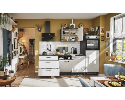 Cuisine moderne avec appareils intégrés, évier et coin repas dans une pièce lumineuse.