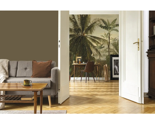 Wohnzimmer mit Sofa, Tisch, Dekoration und einer Wand mit Palmenmotivtapete.