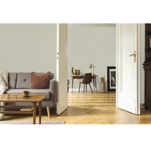 Wohnzimmer mit Sofa, Tisch, Schreibtisch und geöffneter Tür