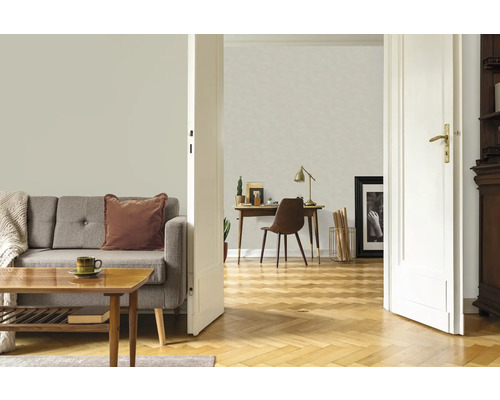 Wohnzimmer mit Sofa, Tisch, Schreibtisch und geöffneter Tür