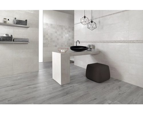 Salle de bain lumineuse avec carrelage imitation bois, lavabo et éléments décoratifs