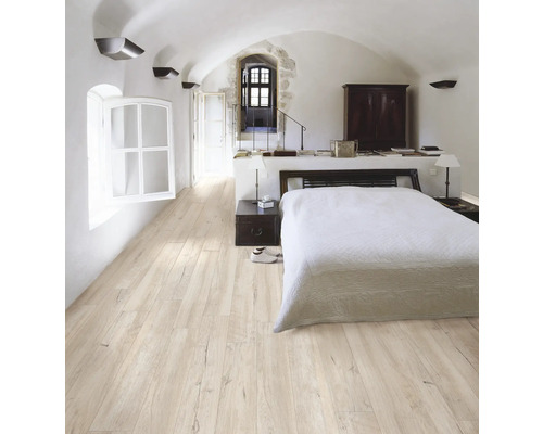 Chambre claire avec parquet, lit et fenêtre