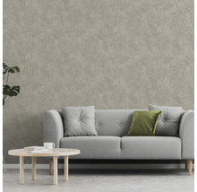 Salon avec canapé, coussins et table basse devant un revêtement mural