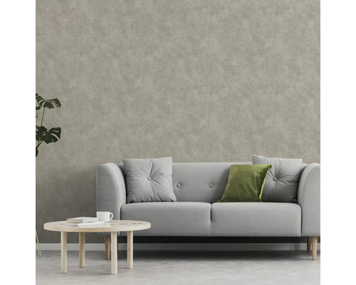 Salon avec canapé, coussins et table basse devant un revêtement mural