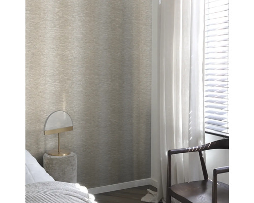 Une chambre avec un papier peint texturé sur le mur, une table de chevet avec une lampe et une chaise près de la fenêtre.