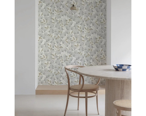 Ambiance de pièce avec papier peint à motifs de feuilles, table ronde et chaise en bois