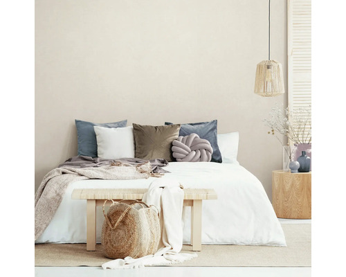 Chambre avec lit, coussins, couvre-lit, banc et décoration pour une ambiance chaleureuse