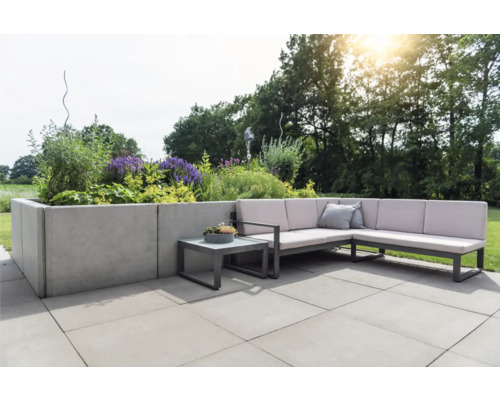 Terrasse mit L-förmiger Gartenlounge, Beistelltisch und bepflanztem Hochbeet.