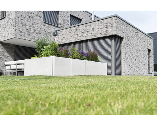 Moderner Garten mit Hochbeet aus Beton und bepflanztem Blumenkasten.