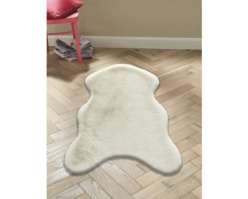Tapis en peau de mouton clair sur plancher en bois