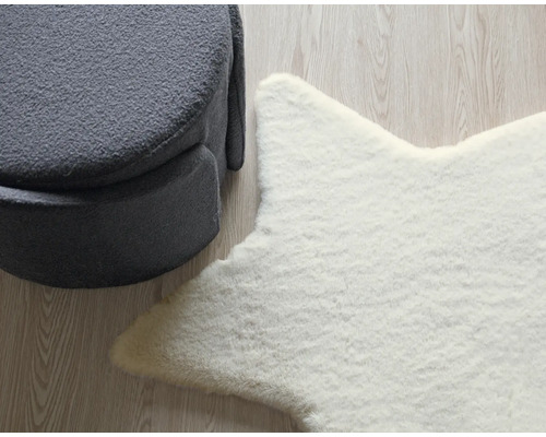 Arrangement décoratif avec un tabouret gris et un tapis étoile blanc