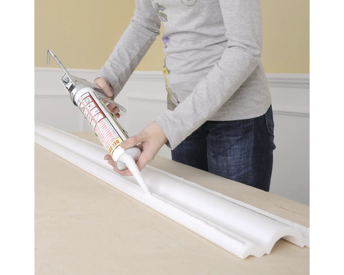Application de produit d''étanchéité avec un pistolet à calfeutrer sur une moulure décorative