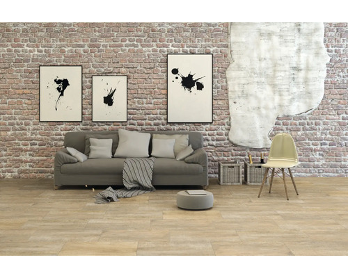 Wohnzimmer mit Sofa, Stuhl und Wanddekoration vor einer Ziegelwand