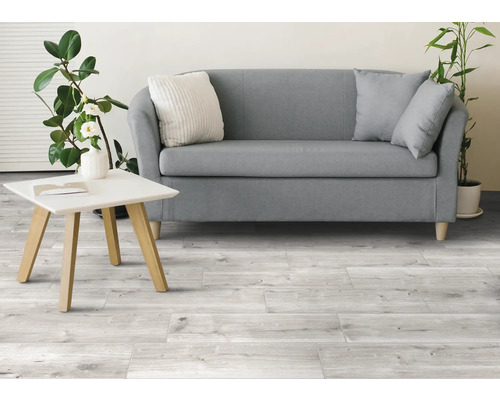 Heller Wohnraum mit Sofa, Tisch und Holzfliesenboden.