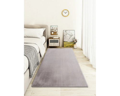 Tapis gris dans une chambre avec lit, table de chevet et décoration