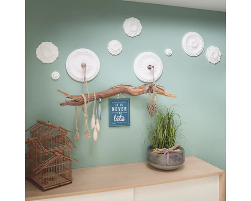 Espace de vie avec suspension en bois, éléments de décoration et plantes sur un buffet