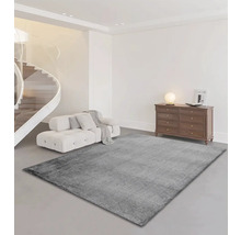 Salon avec tapis gris, canapé, escalier et commode
