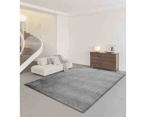 Salon avec tapis gris, canapé, escalier et commode