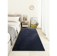 Photo d''intérieur d''une chambre avec un lit et un tapis rectangulaire.