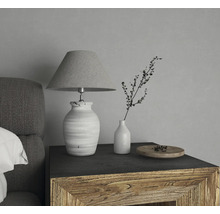 Lampe de table décorative avec abat-jour à côté d''un vase avec une branche sur une table de chevet