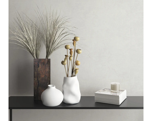 Nature morte décorative avec vases, herbes ornementales, branches décoratives et bougie sur une console