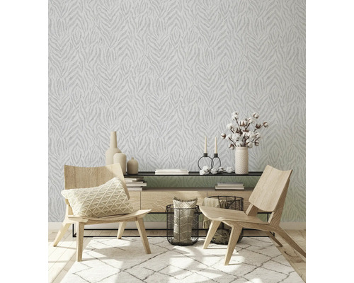 Salon avec papier peint à motifs, tapis et meubles en bois.