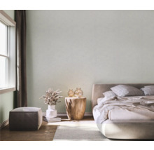 Chambre lumineuse avec lit, table de chevet, décorations et lumière du jour