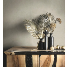Feuilles et boules décoratives dorées dans des vases noirs sur une commode en bois et résine époxy.