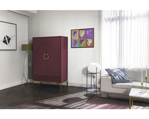 Salon avec armoire rouge, canapé et œuvres d''art au mur