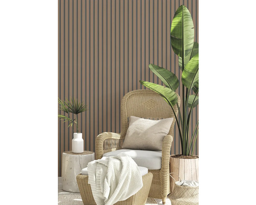 Scène avec mur à lamelles, fauteuil en rotin, coussin, couverture et pots de fleurs
