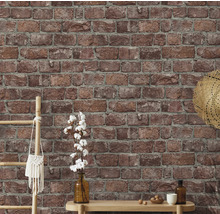 Wand mit Backsteintapete und dekorativen Elementen wie Leiter, Tasche, Hut, Vase und Tisch