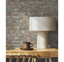 Pièce avec papier peint en briques, bureau et lampe