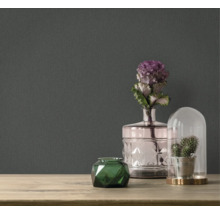 Accessoires décoratifs sur une table devant un papier peint foncé