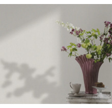 Nature morte avec des fleurs, un vase, une tasse et des pâtisseries sur une table
