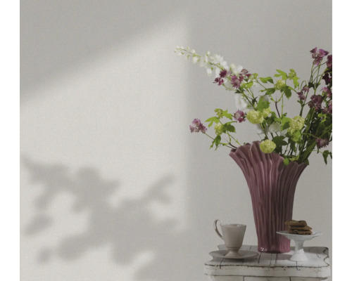 Nature morte avec des fleurs, un vase, une tasse et des pâtisseries sur une table
