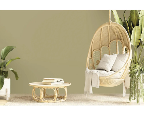 Wohnzimmer mit Rattansessel, Tisch und Pflanzen für eine natürliche Atmosphäre