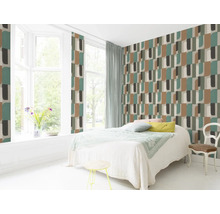Chambre lumineuse avec papier peint à motifs géométriques, lit et siège