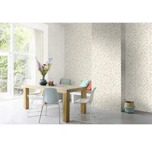 Salle à manger avec papier peint à motifs floraux, table en bois et chaises.