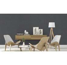 Salon lumineux avec meubles en bois, lampadaire et objets de décoration devant un mur gris