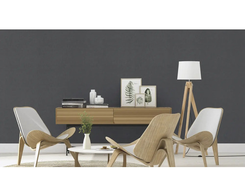 Salon lumineux avec meubles en bois, lampadaire et objets de décoration devant un mur gris