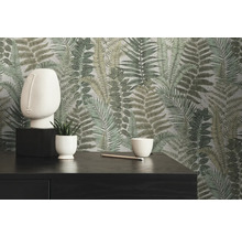 Dekoratives Interieur mit Farnmuster-Tapete, Skulptur, Pflanzen und dunkler Kommode