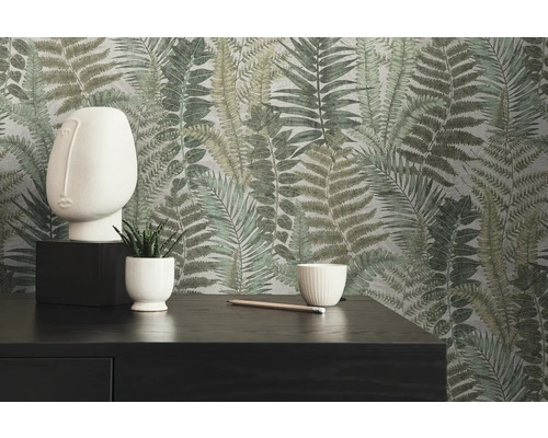 Dekoratives Interieur mit Farnmuster-Tapete, Skulptur, Pflanzen und dunkler Kommode