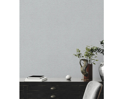 Heller Raum mit grauer Tapete und dunkler Kommode mit Dekoration