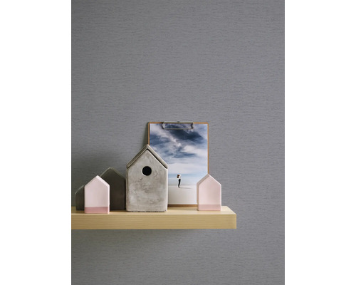 Dekorative Elemente auf einem Regal: Vogelhäuser aus Beton, Holz und ein Bild mit einer Himmelsdarstellung.
