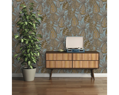 Raumansicht mit gemusterter Tapete, Holzkommode, Schallplattenspieler und Zimmerpflanze.
