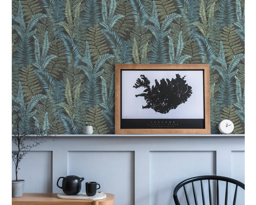 Mur décoratif avec papier peint à motif de fougères, une affiche d''Islande encadrée et des objets décoratifs