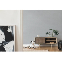 Heller Raum mit gemusterter Tapete, Sideboard, Zimmerpflanzen, Dekoration und Hund
